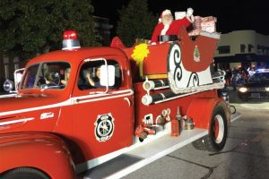 Santa Clause riding on the firetruck.