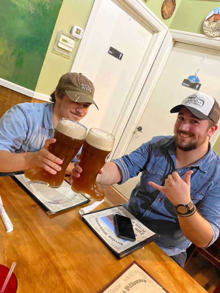 Friends drinking out of glass boots at Zum Rosenhof