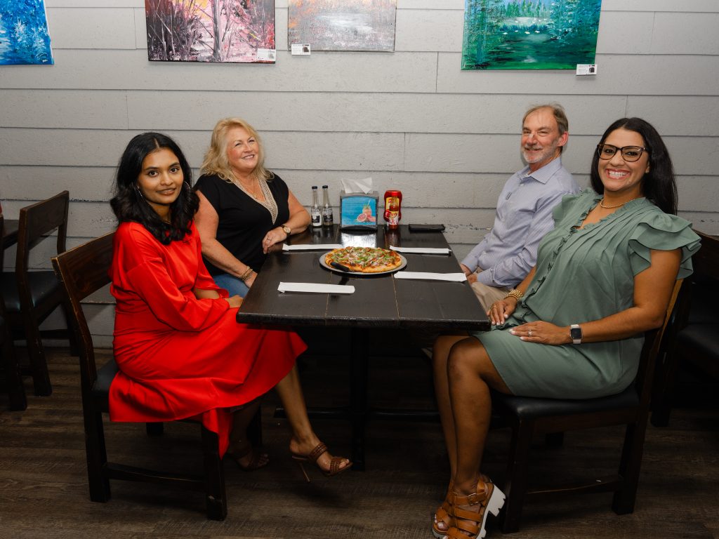 Group sharing pizza at Melody's